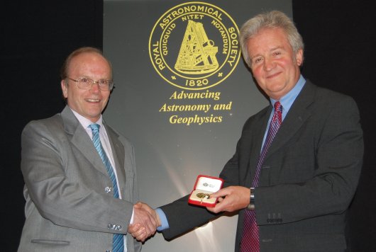An image of Professor Eric Priest being presented with the gold medal by the President of the Royal Astronomical Society.